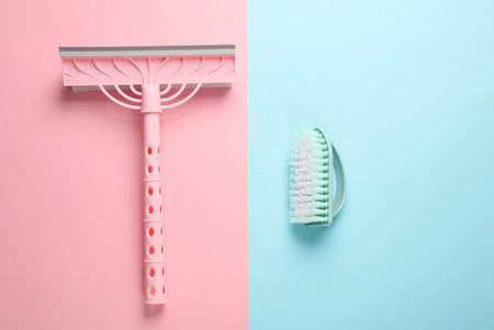 Window cleaning mop and brush on blue pink background. Top view