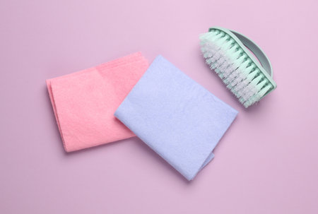 Brush with a rags on a pink background. Cleaning concept