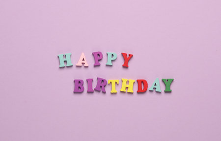 Word happy birthday from colored letters on pink backgroundの写真素材