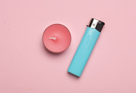 Aroma tea candle with lighter on a pink pastel background. Top viewの写真素材