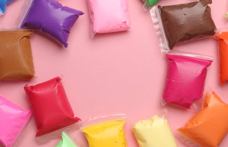 Air plasticine set in packs, pink background. Children's creativity. Top view. Copy spaceの写真素材