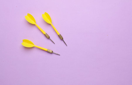 Yellow darts needles on purple pastel backgroundの写真素材