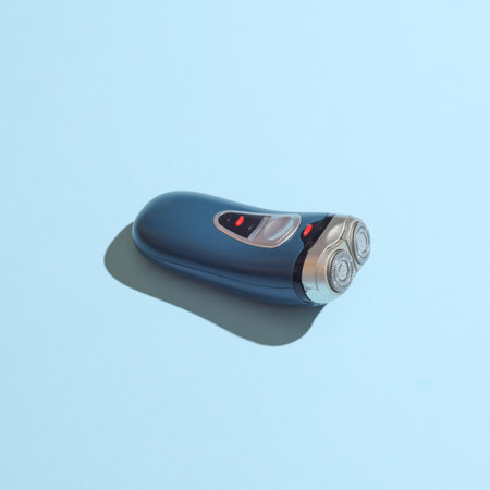 Electric shaver on blue background with shadow