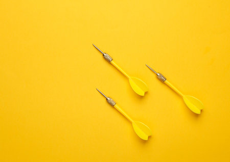 Yellow darts needles on purple yellow background. Top view