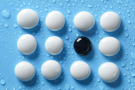 White and black pebbles on a blue background with water drops. spa, relaxation therapyの写真素材