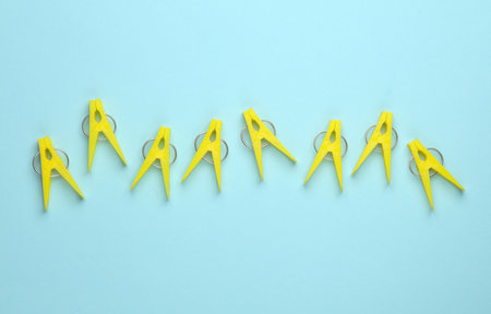 Yellow plastic clothespins on a blue background
