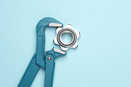Metal adjustable wrench with nut on blue background.の写真素材