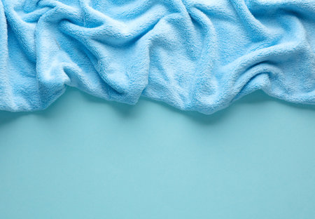 Crumpled blue fleecy fabric on blue background, copy spaceの写真素材
