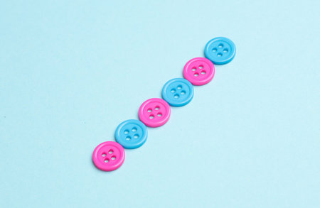 Plastic pink and blue buttons on a blue background