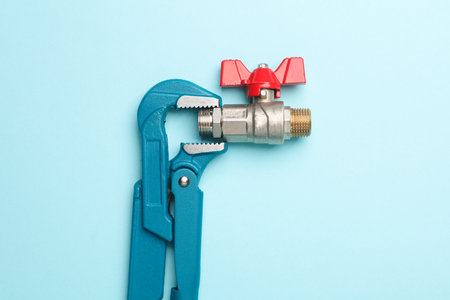 Adjustable wrench with ball valve on a blue background