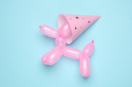 Balloon in the shape of dog with cone hat on blue background. Birthday party conceptの写真素材