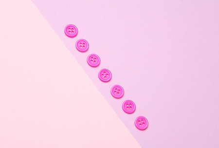 Plastic pink buttons on pastel backgroundの写真素材