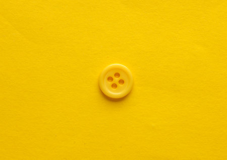 Plastic yellow buttons on a yellow backgroundの写真素材