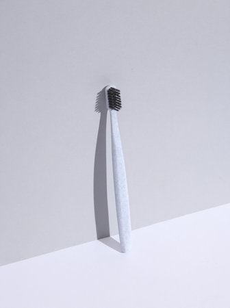 Plastic toothbrush on a white gray background. Beauty concept. Creative layout, minimalism