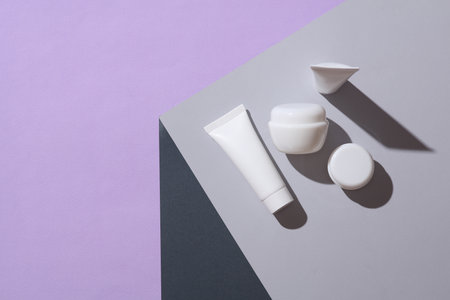 White cream jars and tubes on the corner of gray cube. Optical geometric illusion. Creative layout. Minimalism. Beauty conceptの写真素材