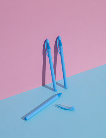 Plastic pink and blue pens on a blue-pink background. Business, education concept. Creative layout,...