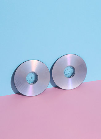 cd disks on a pink blue background. Retro 80s. Outdated technology. Creative layout, minimalism,...