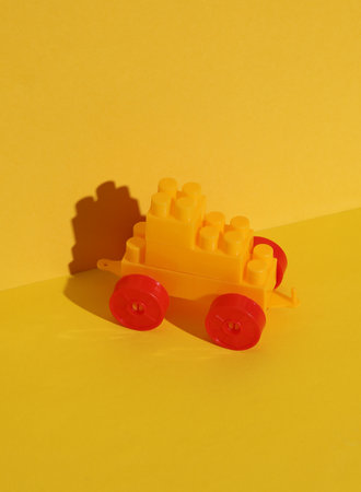 Toy bricks constructor car on a yellow background. Creative layoutの写真素材