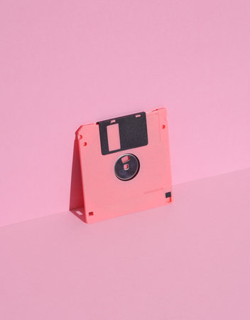 Floppy disk on a pink background. Retro 80s. Outdated technology. Creative layout, minimalism, trendy minimal still lifeの写真素材