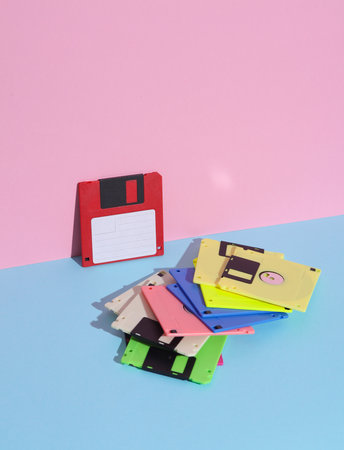 Maany colored Floppy disks on a pink blue background. Retro 80s. Outdated technology. Creative...