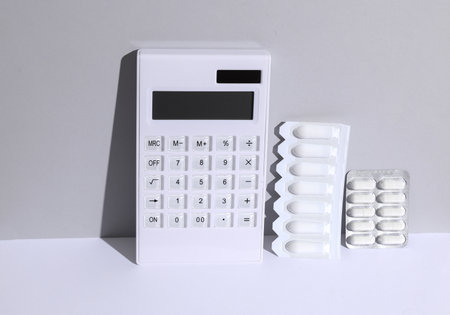 Calculator with medical pills on a white background. The cost of medicines