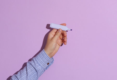 Man's hand in shirt holding marker on purple pastel background with shadow