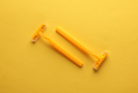 Two yellow razors on a yellow backgroundの写真素材
