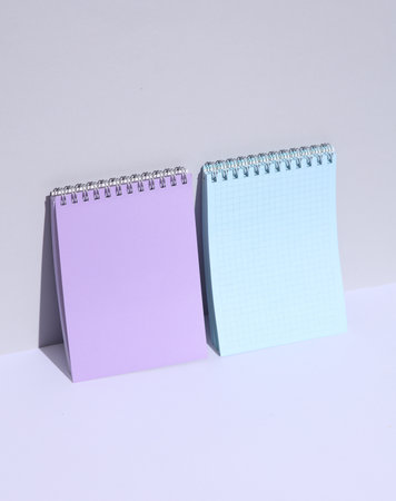 Purple and blue notebooks on a white background with a shadow. Creative layout, minimalismの写真素材