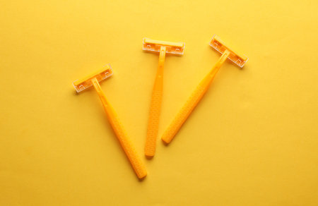 Three yellow razors on a yellow background