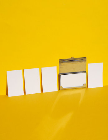 White business cards with metal box on yellow background with shadow. Creative layoutの写真素材