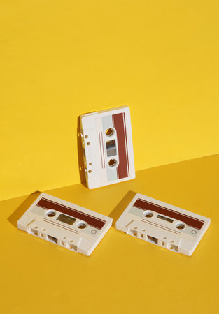 Retro 80s audio cassettes on yellow background with shadow. Creative layout, minimalism, music lover
