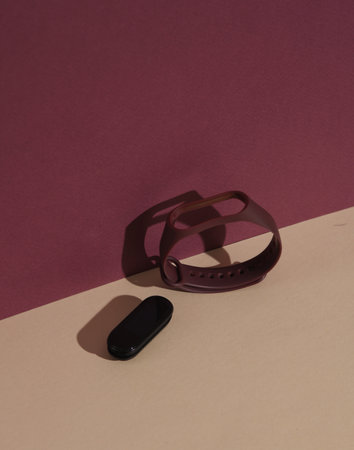 Smart bracelet with interchangeable silicone bracelets on a colored background with a shadow. Creative layoutの写真素材