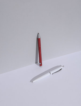 Red and white pen on a white background with shadow. Creative layout. Minimal business concept. Conceptual still lifeの写真素材