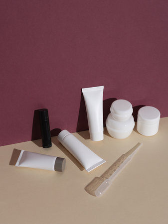 Accessories for handmade cream on beige burgundy background with a shadow. Beauty conceptの写真素材
