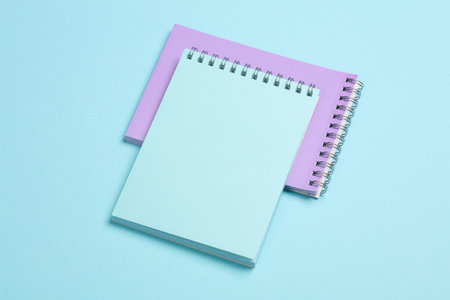 Two notebooks on blue pastel background. Minimalism. Creative layout