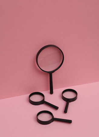 Magnifying glasses on pink background. Creative layout. Minimal business concept. Conceptual still lifeの写真素材