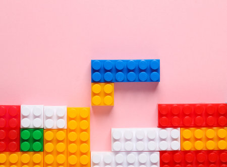 Toy blocks of bricks in the form of a retro video game on a pink background