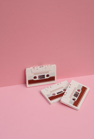 Outdated technologies. Retro 80s audio cassettes on pink background. Creative layout