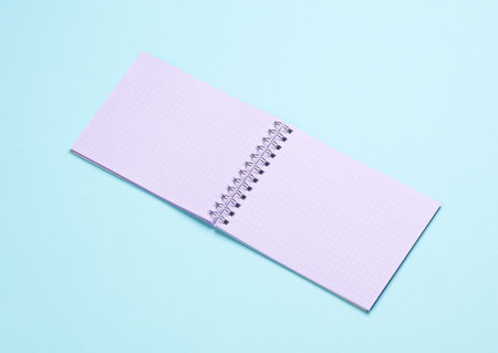 Open purple pastel notebook on blue background
