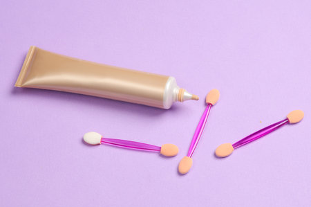 Set of applicators for makeup and foundation tube on purple pastel backgroundの写真素材