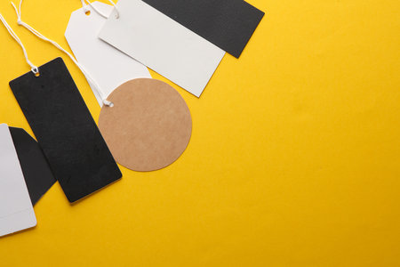 Different price tags on yellow background. Mockup, template for design. Copy spaceの写真素材