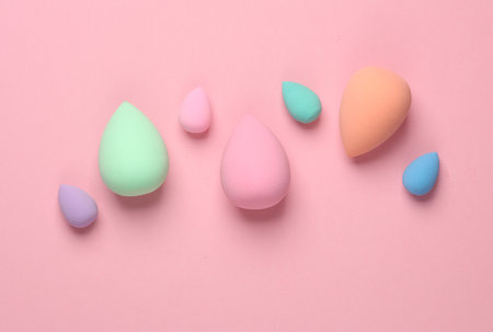 Make-up sponges, cosmetic beauty blenders on pink blue background. Top view. Flat layの写真素材