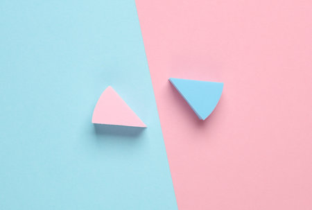 Triangular make-up sponges on a blue-pink pastel background. Top viewの写真素材