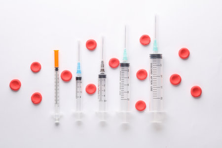 Syringes and Red blood cells on white background