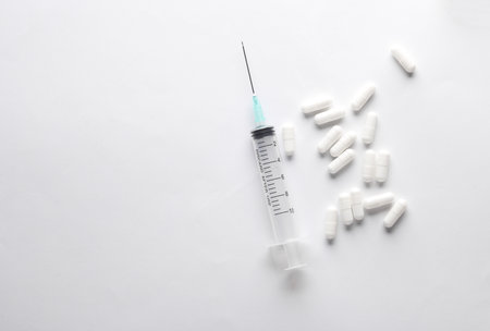 Syringe with pills on white backgroundの写真素材
