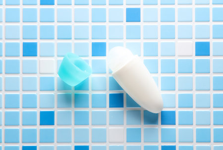 Antiperspirant roller on a blue tile. Beauty concept