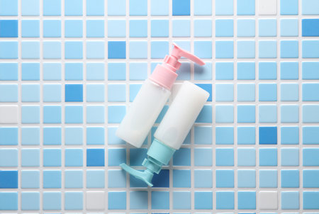 Ð¡ream dispensers bottle on blue tiles