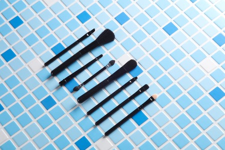 Makeup brushes on blue tiles. Beauty concept