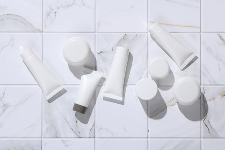 White Cream tubes and jars on tiles. Beauty concept. Mockup for design. Top viewの写真素材