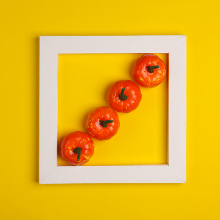 Plastic pumpkins in white frame on yellow background. Creative layout. Halloween. Minimalism